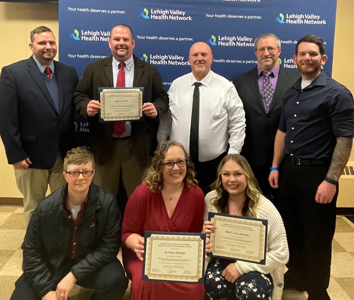 New paramedics posing with their certifications.